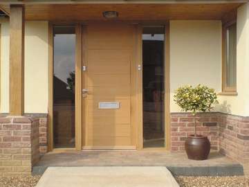 Chester : Installation of a contemporary Kell 1 door design manufactured from oak with natural stain finish . Brushed Stainless letter box and handle 